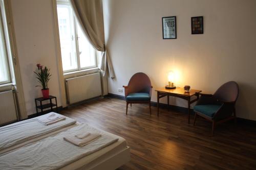 a bedroom with a bed and two chairs and a table at Pension Wienderland in Vienna