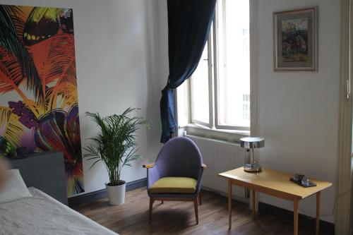a bedroom with a chair and a table and a window at Pension Wienderland in Vienna
