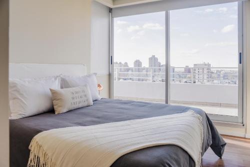 a bedroom with a bed with a large window at Top Rentals WOW Nuñez in Buenos Aires