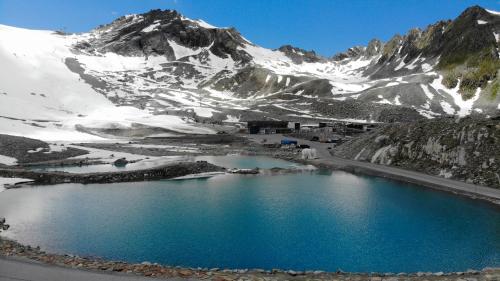 a blue lake in front of a snow covered mountain at Alpenspirit in Sölden