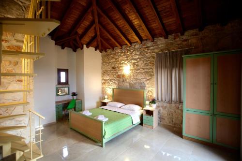 a bedroom with a bed and a stone wall at Fruit Garden Villas in Kriopigi