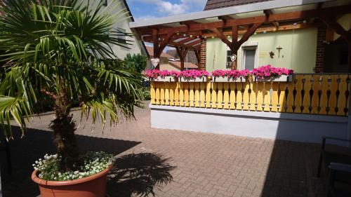 a house with a fence and flowers in a yard at Gästehaus Brigitte Duri in Rust