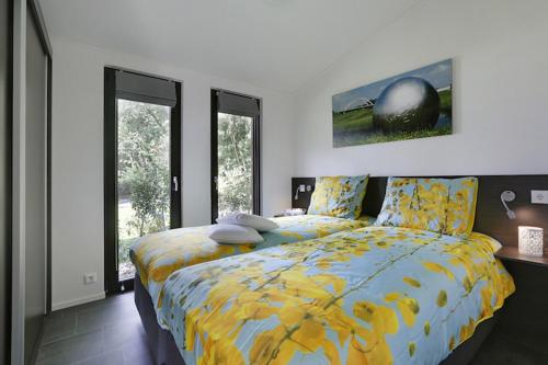 a bedroom with a bed with a yellow comforter at Bospark Markelo in Markelo
