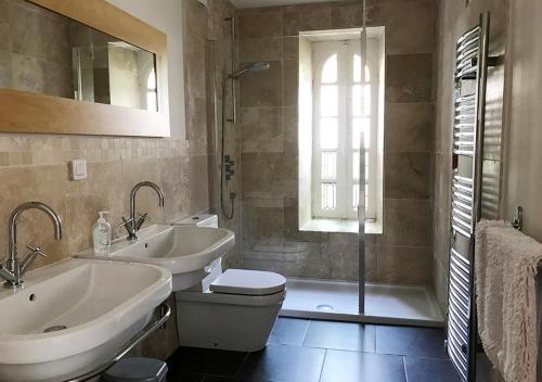 La salle de bains est pourvue de 2 lavabos, de toilettes et d'une douche. dans l'établissement Val Rive - Brandily Apartment, à Dinan