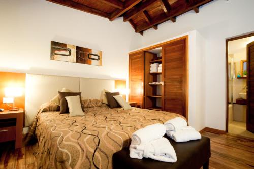 Un dormitorio con una cama grande con dos toallas. en Cabañas Bosque del Nahuel, en San Carlos de Bariloche