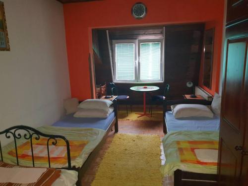 新瓦羅許的住宿－Vila De turist，带三张床、桌子和窗户的房间