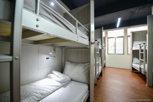 a room with two bunk beds and a hallway at REST backpacker in Tainan