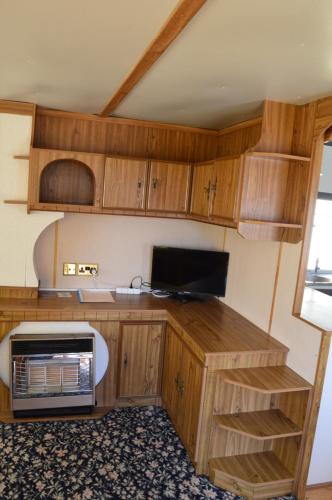 斯文托伊Jūros g. 41, Delta的配有木质橱柜和微波炉的厨房