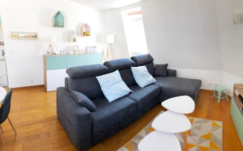 a living room with a black couch and a table at Les quais de Trouville in Trouville-sur-Mer