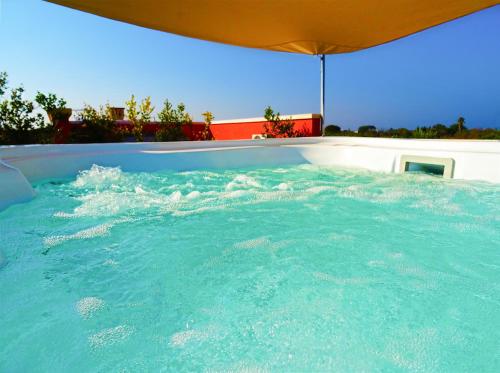 una gran piscina de agua azul con sombrilla en Biancolivo Gallipoli in Salento, en Gallipoli