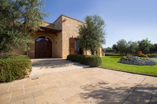 a brick house with a large wooden door at Biancolivo Gallipoli in Salento in Gallipoli