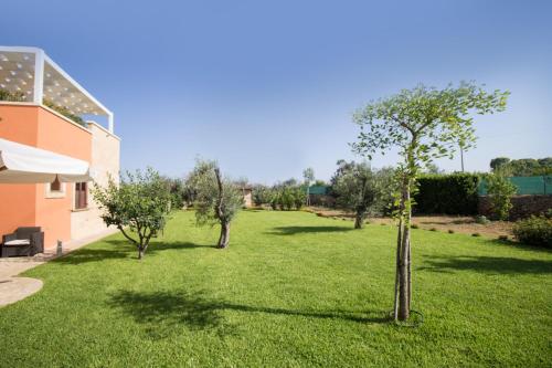 a green yard with trees and a building at Biancolivo Gallipoli in Salento in Gallipoli