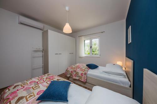 ŽrnovnicaにあるHoliday Home Cherry Treeのベッド2台と窓のある寝室