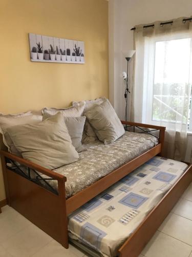 a bed in a room with a window at AP Roberand in Albufeira