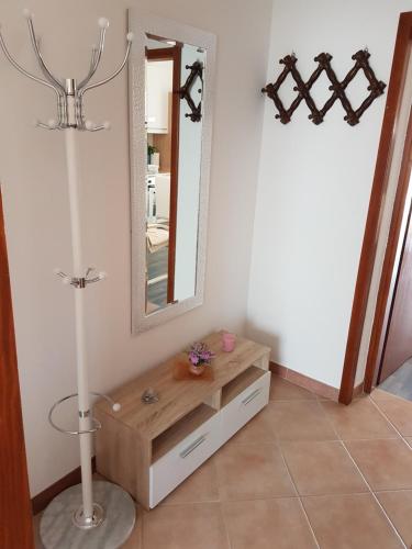 a bathroom with a vanity with a mirror and a lamp at Apartman Dea in Crveni Vrh