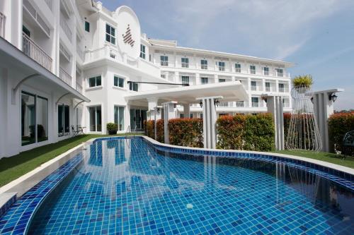 a swimming pool in front of a building at Chada@Nakhon in Nakhon Si Thammarat