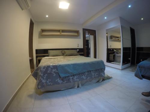 a bedroom with a bed and a large mirror at Hollyster Hotel in Curitiba