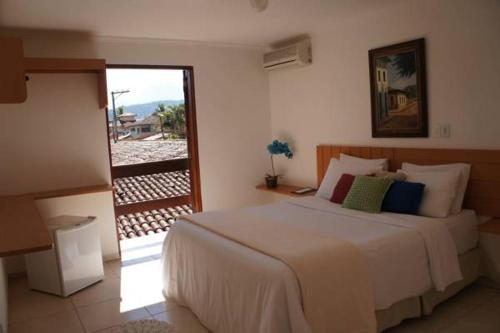 a bedroom with a large bed and a balcony at Pousada do Tesouro in Paraty