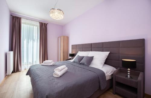 ワルシャワにあるAwangarda Home Apartmentのベッドルーム1室(大型ベッド1台、タオル2枚付)