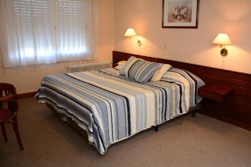 a bedroom with a bed with a striped blanket at Hotel Crown in Melo
