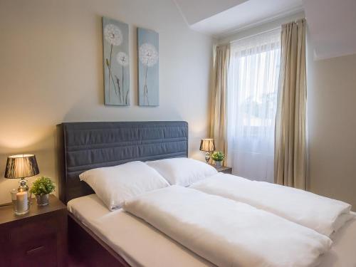 a bedroom with a large white bed with a window at VacationClub - Rezydencja Park Apartament 30 in Mielno