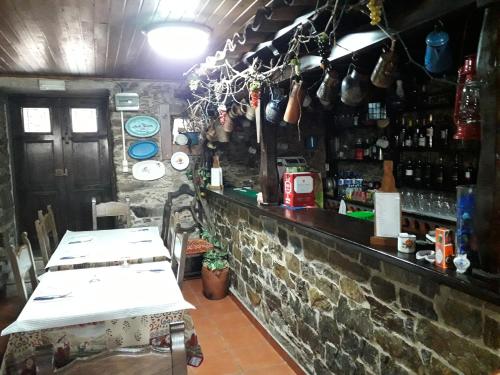 un bar con una pared de piedra y un mostrador con mesas en Quinta da Moagem en Macedo de Cavaleiros