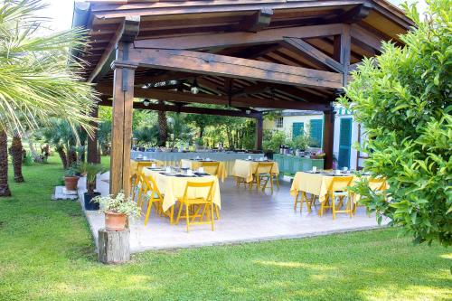 a dining area with tables and chairs in a garden at B&B Da Pio in Pietrasanta