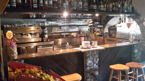eine Küche mit einer Theke und Stühlen in einem Restaurant in der Unterkunft Rifugio "Mai Tardi" in Madesimo