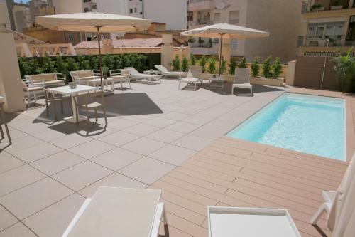 a patio with a pool and tables and chairs at Intelier Rosa in Castellón de la Plana