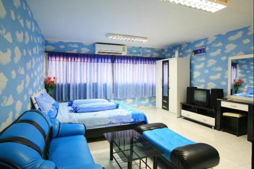 Habitación con cama, sofá y TV. en Deluxe at Popular Condo, en Bangkok