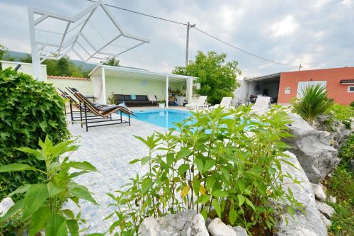a swimming pool in a yard with chairs and a house at Villa Iva in Kraj