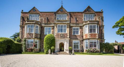 a large brick house with a large driveway at Goldsborough Hall in Knaresborough