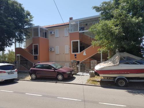samochód i łódź zaparkowane przed budynkiem w obiekcie Apartment Vinodol w Novim Vinodolskim
