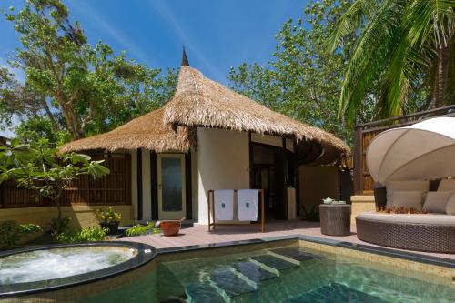 a resort with a swimming pool and a hut at Banyan Tree Vabbinfaru in Male City