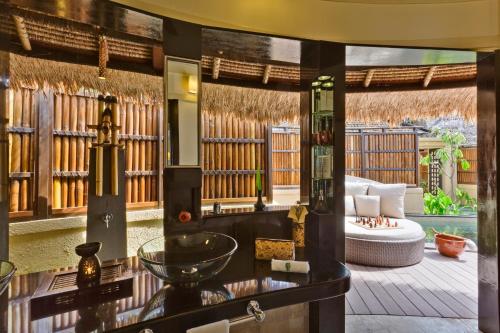 a living room with a view of a patio at Banyan Tree Vabbinfaru in Male City