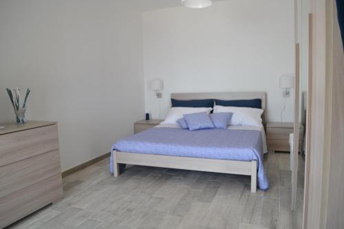 a bedroom with a bed with blue sheets and pillows at Charming Place 2 Taormina in Taormina