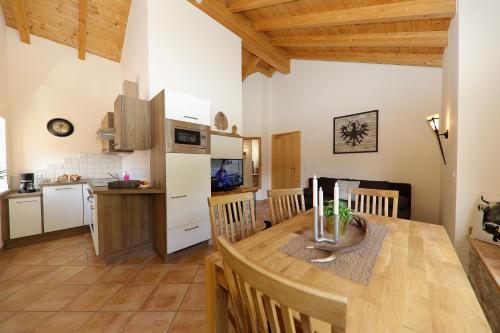 a kitchen and dining room with a wooden table at Seeapart Pöder in Ladis