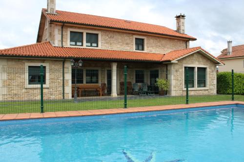 a house with a swimming pool in front of a house at A Lúa do Camiño in Melide