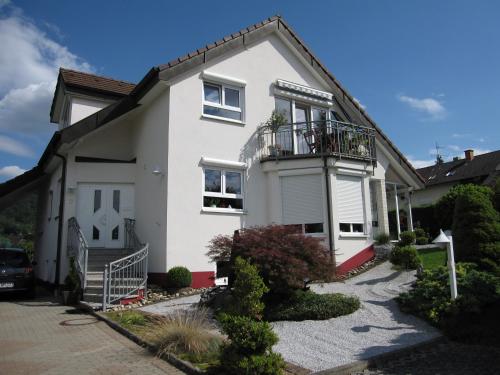 a white house with a balcony at Ferienwohnung Wölfle in Friesenheim