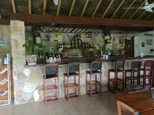 a bar with four stools in a restaurant at Hotel Gerald in Contadora