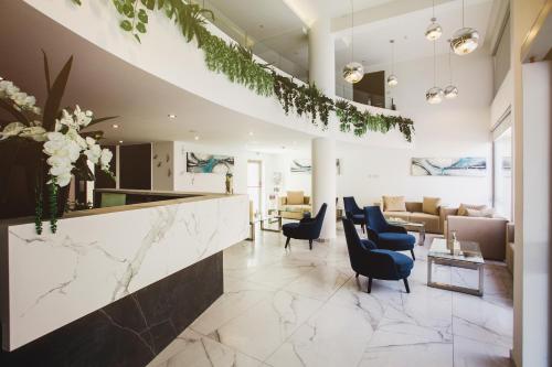 a lobby with a reception counter and chairs and a couch at Frangiorgio Hotel in Larnaka