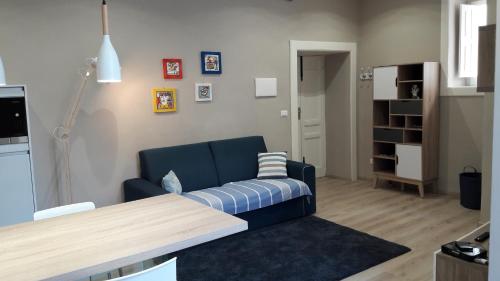 ein Wohnzimmer mit einem blauen Sofa und einem Tisch in der Unterkunft 9 House Ortigia in Syrakus