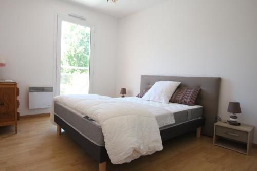 une chambre avec un grand lit et une fenêtre dans l'établissement Grand Appt T2 terrasse SUD + PKG - 150m de la plage d'Eyrac, à Arcachon