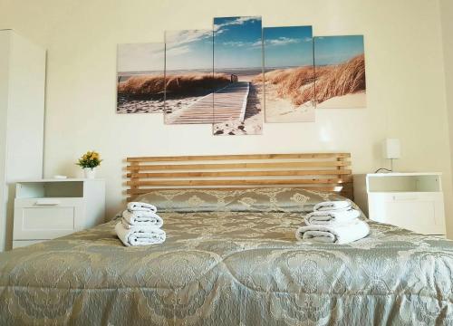 Casola di NapoliにあるIl Rifugio Sui Due Golfiのベッドルーム1室(壁に4つの絵画が飾られたベッド1台付)
