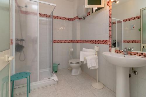 y baño con ducha, aseo y lavamanos. en Mini Hotel en Orbetello