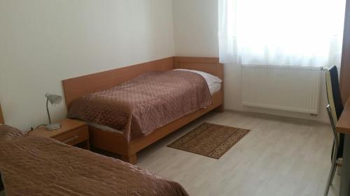 a small bedroom with two beds and a window at Rekreačný dom Flóra in Veľký Meder