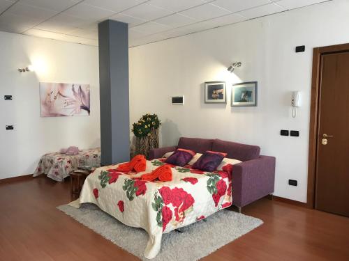 een slaapkamer met een bed en een bank bij Da Lenny: a due passi dal centro storico in Treviso