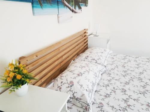 a bedroom with a bed with a wooden headboard at Il Rifugio Sui Due Golfi in Casola di Napoli