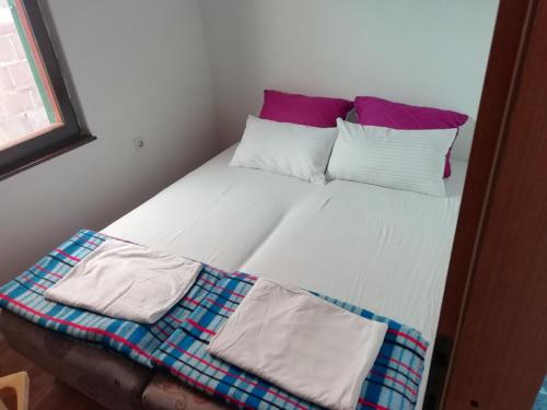 a bed with two pillows and a blanket on it at apartman holiday budva in Budva