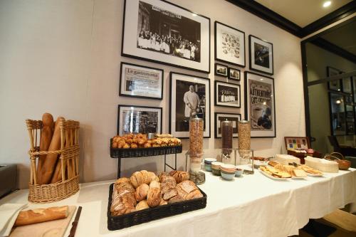 a table with various types of bread and pastries on it at ibis Styles Dijon Central in Dijon